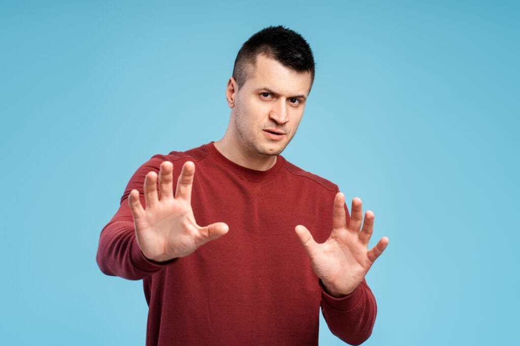 Dos and Don’ts When Falsely Accused of Domestic Violence 1 1920 serious man showing stop sign with both hands on blue background